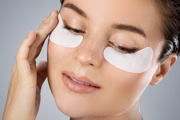 Young and beautiful woman with hydrating eye patches under her eyes o - Foto, Imagen