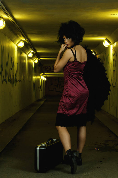 Strange and freaky woman with a disheveled hair in the dark tunnel - Foto, Bild
