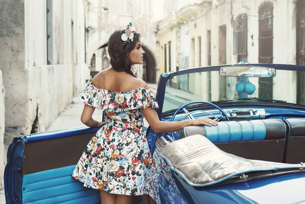 Woman wearing beautiful dress and retro convertible car at Havana city - Фото, изображение