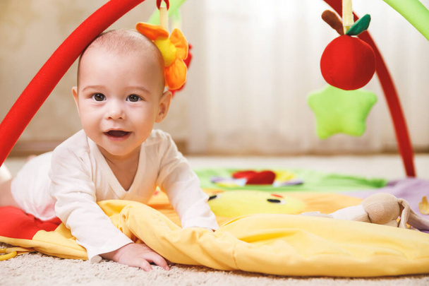 Cute little baby is playing on the activity mat  - Foto, imagen