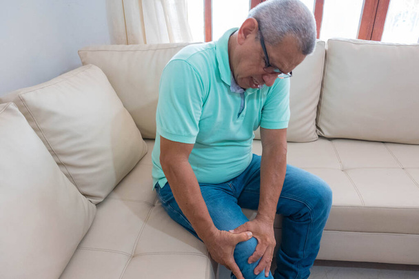 Un vieil homme à la retraite tenant sa main sur son genou douloureux
 - Photo, image