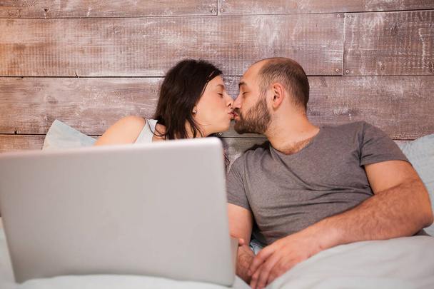 Coppia in pigiama baciare posa a letto
 - Foto, immagini
