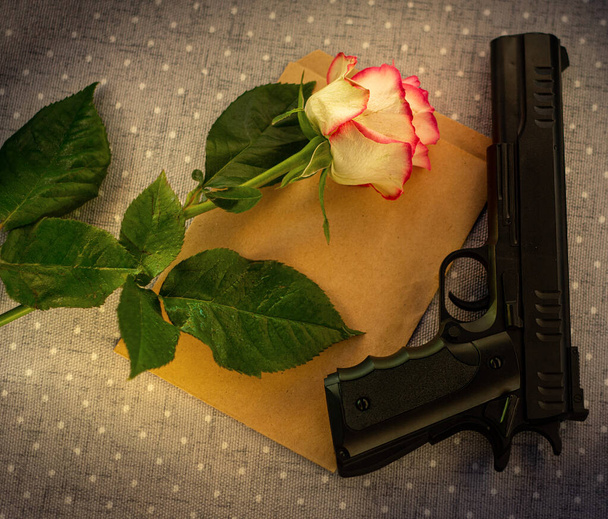 Still life with envelope, gun and rose in vintage colors - Photo, Image