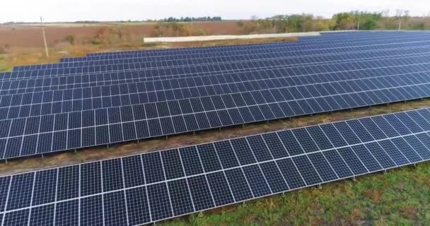 Solar power station view from above, flight over a large solar station near the forest - Materiał filmowy, wideo