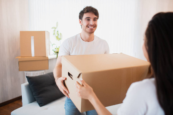 Young couple carrying big cardboard box at new home.Moving house. - Fotoğraf, Görsel