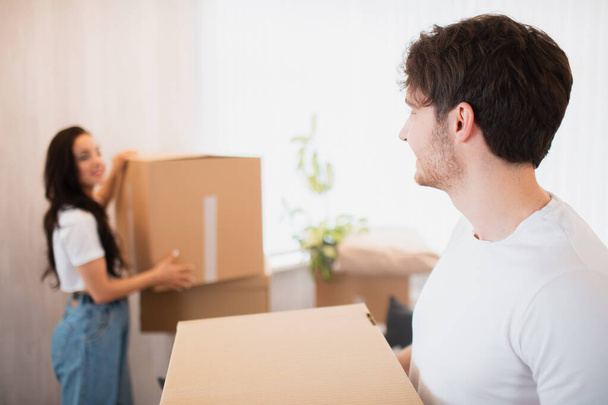 Jeune couple portant une grande boîte en carton à la nouvelle maison.Déménagement. - Photo, image