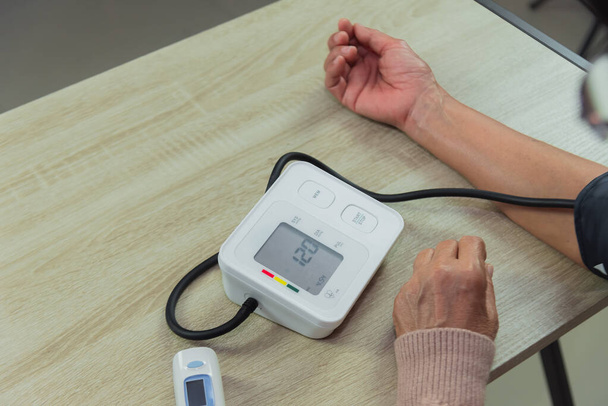 Tonometresi olan yaşlı kadın kan basıncını ölçüyor. - Fotoğraf, Görsel