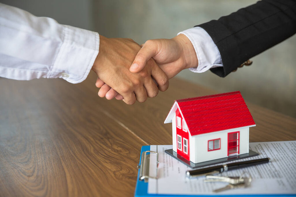 Üzletemberek és befektetők a házkereskedelemben. Fogjuk egymás kezét a bizalomhoz. Kéz a kézben, hogy egy otthoni adásvételi szerződés.Kéz a kézben ingatlanügynökök vagy brókerek. Elégséges a szerződés. - Fotó, kép