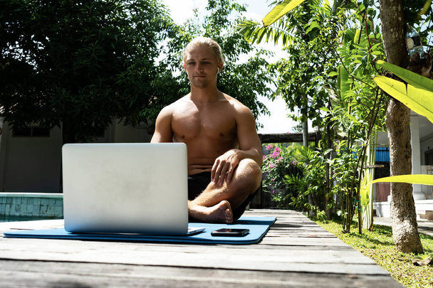 handsome man working with laptop computer at the poolside - Fotografie, Obrázek