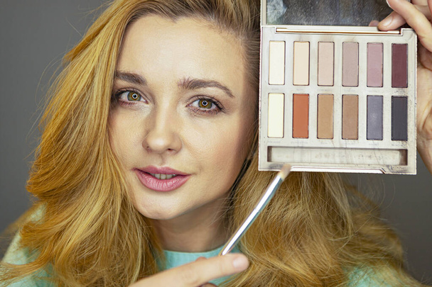 Beauty blogger is testing makeup. A young girl advises makeup. Cute girl checks eyeshadow. - Фото, изображение