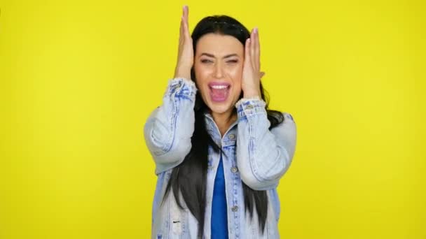 Vrouw schreeuwt, leunende handen tegen hoofd op gele achtergrond met kopieerruimte - Video