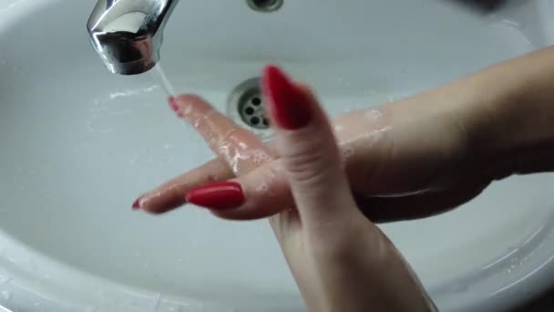 Το κορίτσι πλένει καλά τα χέρια του με σαπούνι στο μπάνιο. Το νερό ρέει από τη βρύση. Αποτρέψτε τη μόλυνση. Κοντινό πλάνο. Coronavirus πανδημία πρόληψη πλένουν τα χέρια με ζεστό νερό σαπούνι. - Πλάνα, βίντεο