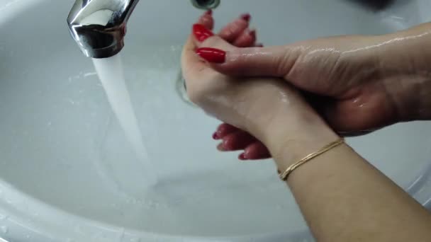 Chica se lava las manos a fondo con jabón en un baño. El agua fluye del grifo. Prevenir la infección. Primer plano. Prevención pandémica del Coronavirus lávese las manos con agua tibia
. - Metraje, vídeo