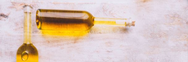 Różne butelki ze szkła olejowego na drewnianym tle, przestrzeń do kopiowania. Oleje z pierwszego tłoczenia z nasion, roślin i warzyw, słonecznik, rzepak, oliwa z oliwek, bogate w przeciwutleniacze - Zdjęcie, obraz
