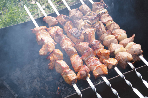 Traditional skewers on skewers and barbecue. Springtime outdoor recreation. Grilled meat. - Photo, Image
