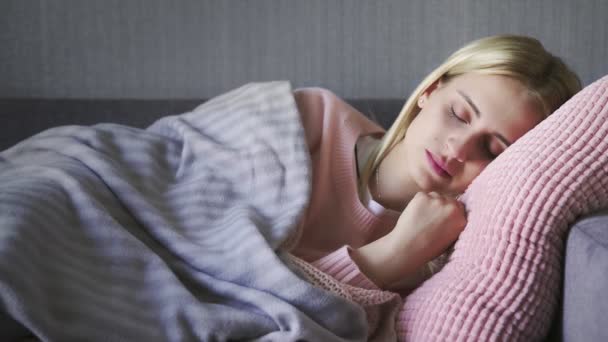Fiatal gyönyörű nő felébred a kanapén a nappaliban - Felvétel, videó