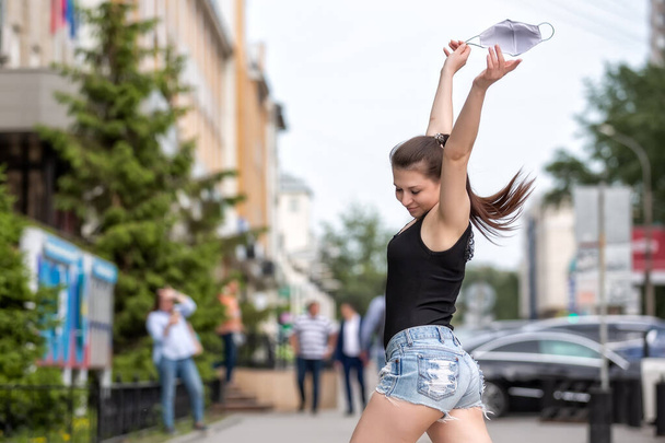 Happy girl rejoices at the end of coronavirus. Girl dancing in the street.  Girl rejoices at the end of quarantine - Zdjęcie, obraz