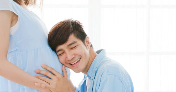 happy pregnant couple expecting baby and listen to baby - Foto, imagen