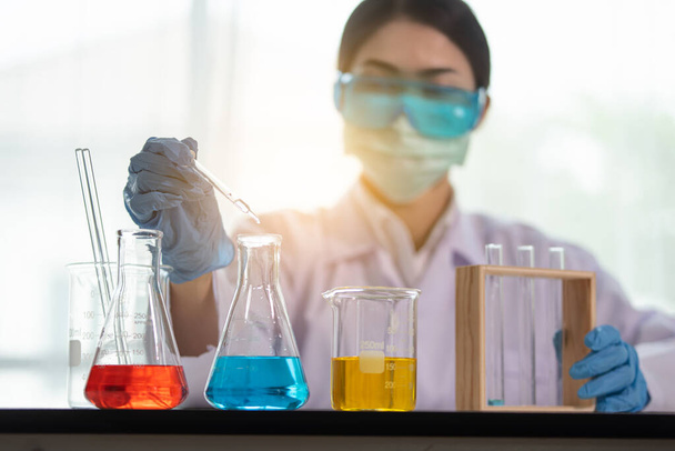Jonge Aziatische vrouwen wetenschapper met reageerbuis maken van onderzoek in klinisch laboratorium, Wetenschap en chemie concept, Medisch technoloog - Foto, afbeelding