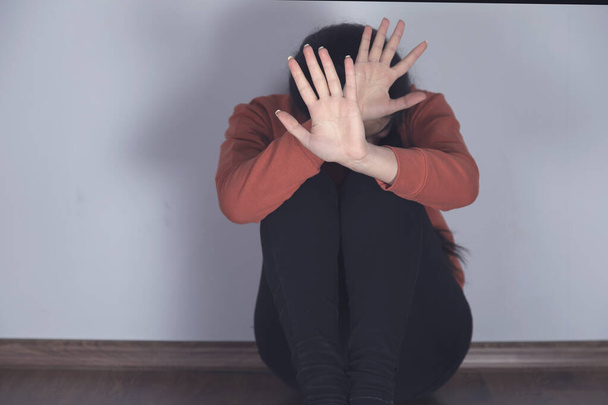 sad woman hand stop sign sitting on the floor - Foto, afbeelding