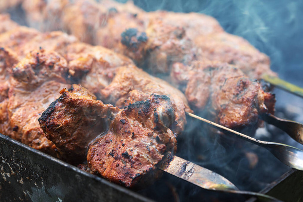 Vlees op spiesen. Gemarineerde shashlik bereiden op een barbecue grill boven houtskool. Smakelijk vlees gegrild op spiesen. Ik kook shashlik. Grillvarkensvlees op steenkool - Foto, afbeelding