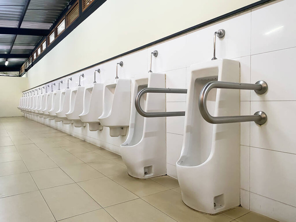 Desenho de urinóis brancos dos homens, close-up linha de urinóis ao ar livre homens banheiro público, conceito urinário
. - Foto, Imagem