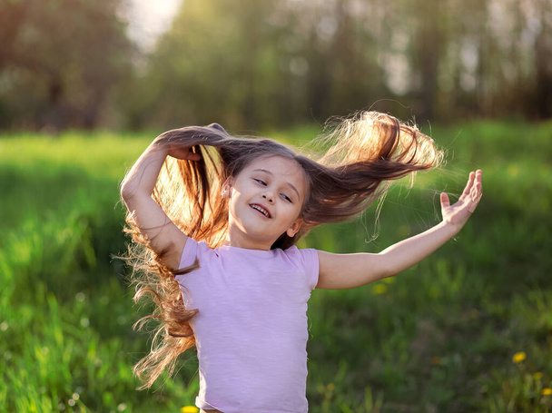little girl dancing in nature with long hair - Foto, Bild