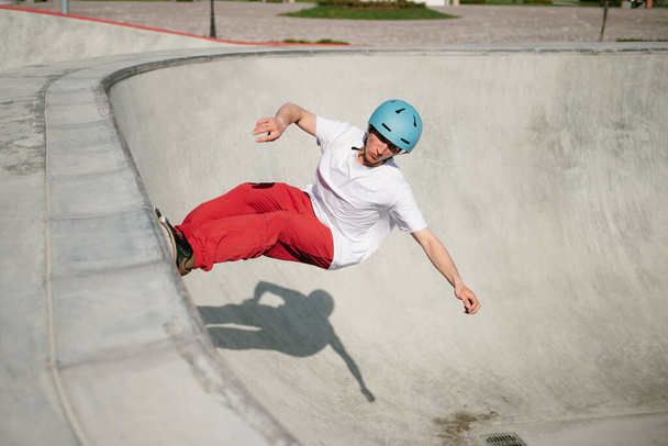 Young man doing skateboarding trick outdoor - Fotó, kép