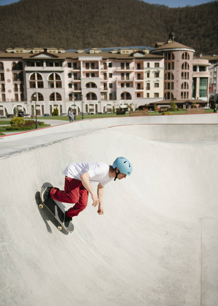 Jeune homme faisant du skateboard en plein air dans un skate park
 - Photo, image