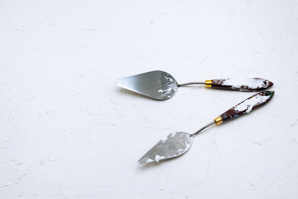 Masilla blanca, cuchillos de masilla y espátulas. Construcción, reparación y decoración
 - Foto, imagen