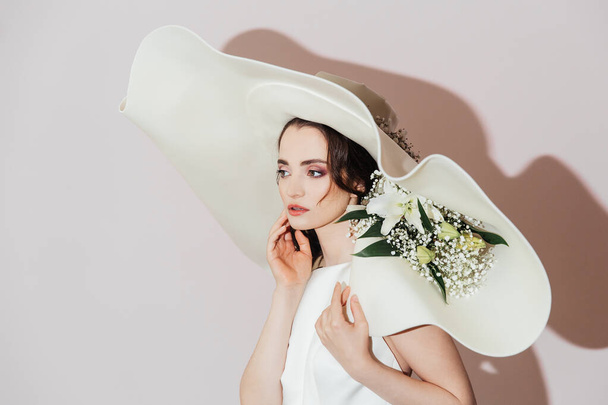Luxe bruid met een hoed en bloemen in een hoed, mode - Foto, afbeelding