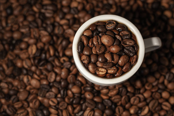 背景にコーヒー豆とコーヒー豆のカップ - 写真・画像