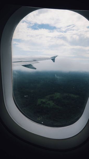 LETICIA, AMAZONAS, COLOMBIA - CIRCA DECEMBER 2019: view of Amazon jungle rainforest from the airplane window and white clouds.  - Zdjęcie, obraz