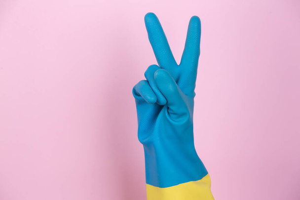 Чистящая рука в перчатках делает победный жест
 - Фото, изображение