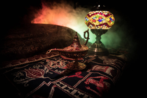 Antique Aladdin arabian nights genie style oil lamp with soft light white smoke, Dark background. Lamp of wishes concept - Photo, Image