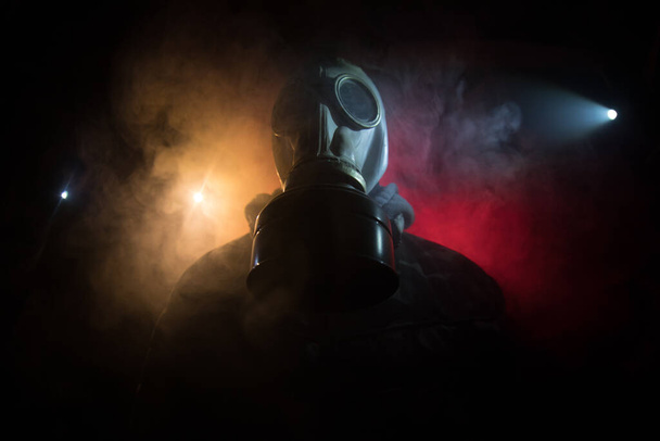 Çevre felaketi. Karanlık bir arka planda gaz maskeli kıyamet sonrası hayatta kalan biri. Gaz maskesi takan bir adamın dramatik portresi. Radyasyon koruması demek. Seçici odak - Fotoğraf, Görsel