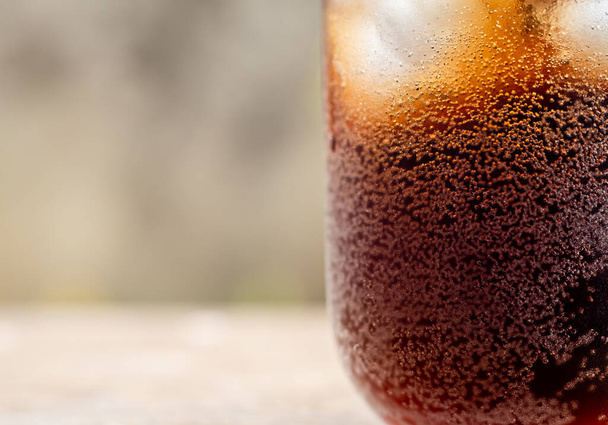 Close up Glass filled with carbonated cola soft drink with ice cubes. selective focus - Photo, Image