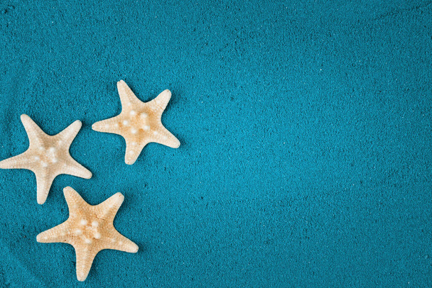 Starfish on the blue sand copy space. Colored sand. - Foto, Imagen