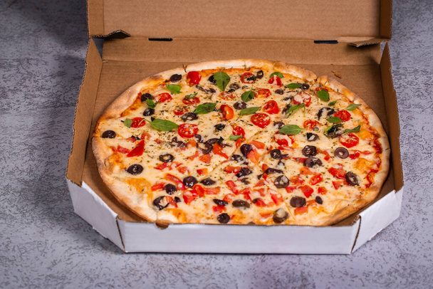 Deliciosa pizza em caixas de entrega em fundo cinza
. - Foto, Imagem