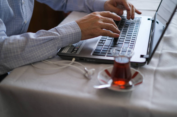 Мужчина средних лет работает с ноутбуком дома в карантинные дни
. - Фото, изображение