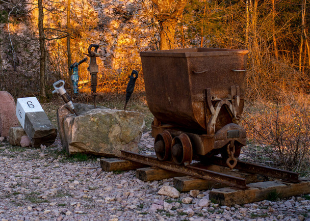 Rozsdás régi bányászati kocsi légkalapáccsal, légkalapáccsal, pneumatikus kalapáccsal a nagy kőben. - Fotó, kép