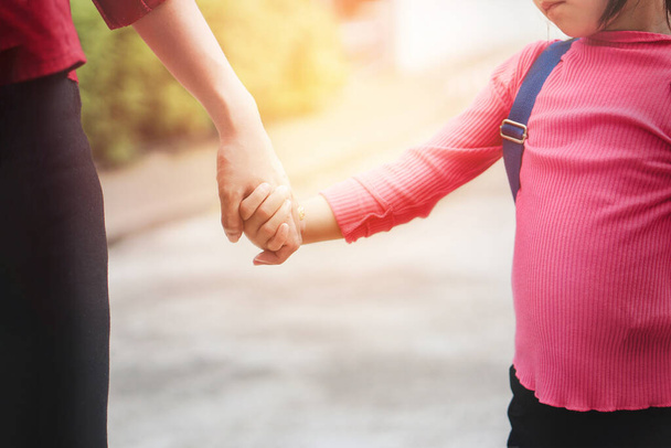 Back to school concept, Mother or parent holding hand  daughter or pupil with backpack to school, Selective focus. - 写真・画像