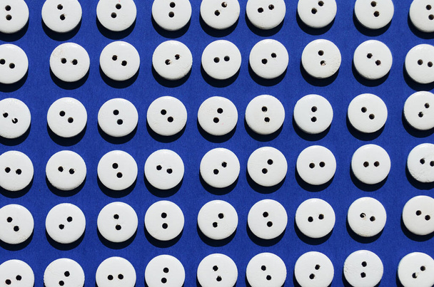 Pattern white wooden buttons on a blue background view from above - Photo, Image