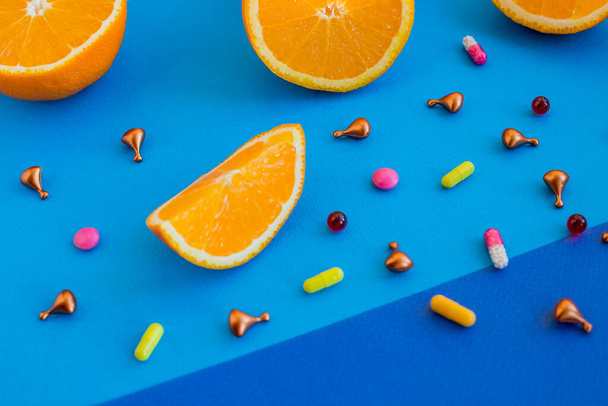 Multivitaminen en supplementen met verse sinaasappel en lamon op witte houten ondergrond. - Foto, afbeelding