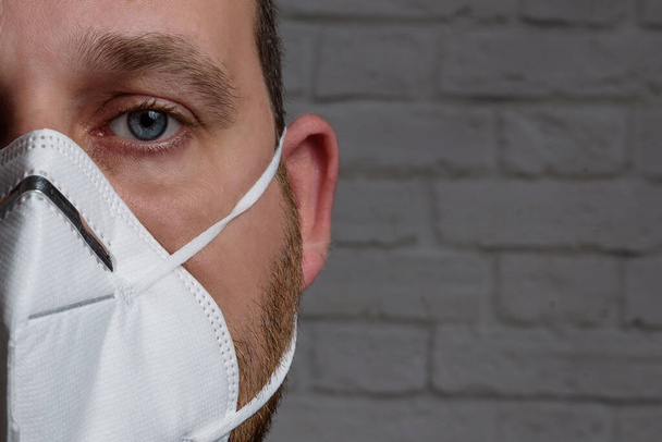 Молодий чоловік носить захисну медичну маску KN-95 . Запобігання поширенню вірусу та епідемії, захисна маска для фільтрації ротової порожнини. Хвороби, грип, забруднення повітря, концепція вірусу корони
 - Фото, зображення