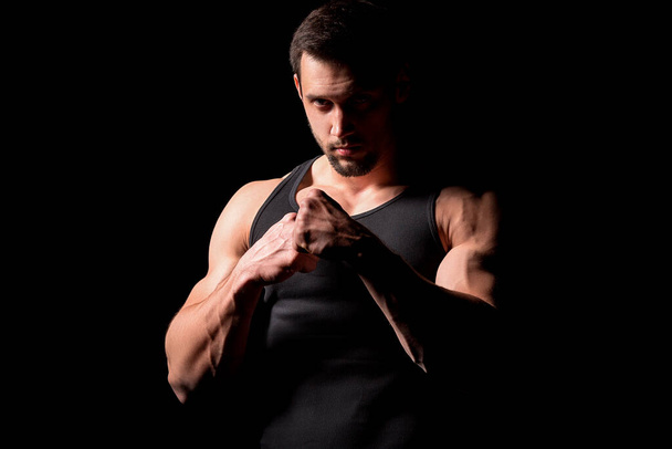 Silhouette de chasseur. bel homme athlétique dans la boxe stand sur un fond sombre
. - Photo, image