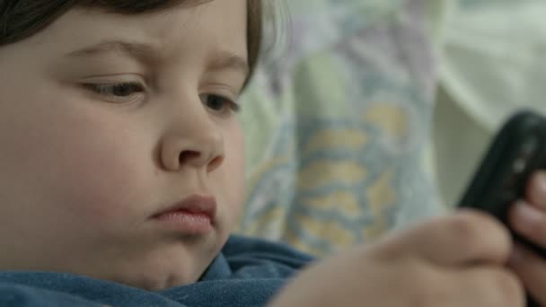 jongen met gebrek aan aandacht van ouders de hele dag kijken cartoon op de telefoon terwijl ouders werken - Video