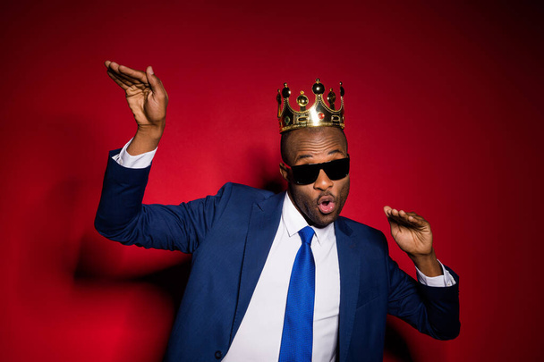Closeup photo of handsome attractive dark skin business guy bossy person dancing office event golden diadem on head wear sun specs formalwear suit tuxedo isolated burgundy background - Foto, immagini