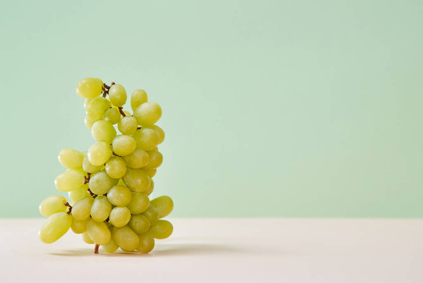 Tasty bunch of grapes isolated on green background. Summer healthy fruits. Diet food concept. Copy space for text - Photo, image