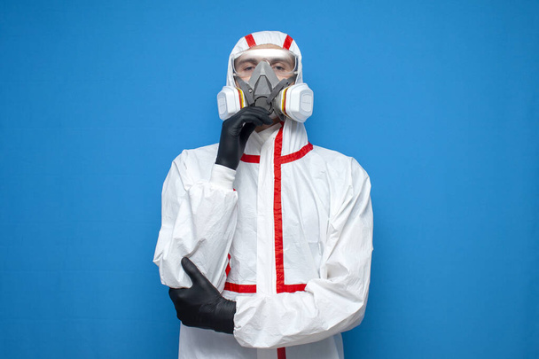 Arzt Virologe im Chemikalienschutzanzug und Atemschutzmaske auf blauem, isoliertem Hintergrund, Virusepidemie, Gesundheitshelfer - Foto, Bild